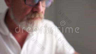 一个灰色的成熟男人，戴着眼镜，拿着笔记本电脑工作。 快乐晚年，积极养老，经营理念